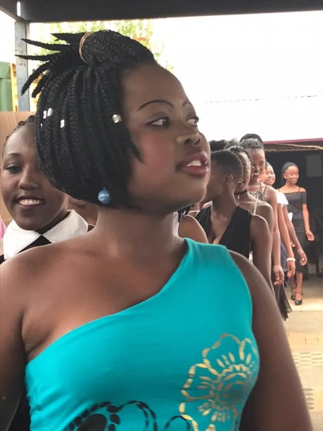 A young woman smiling before stepping onto the runway