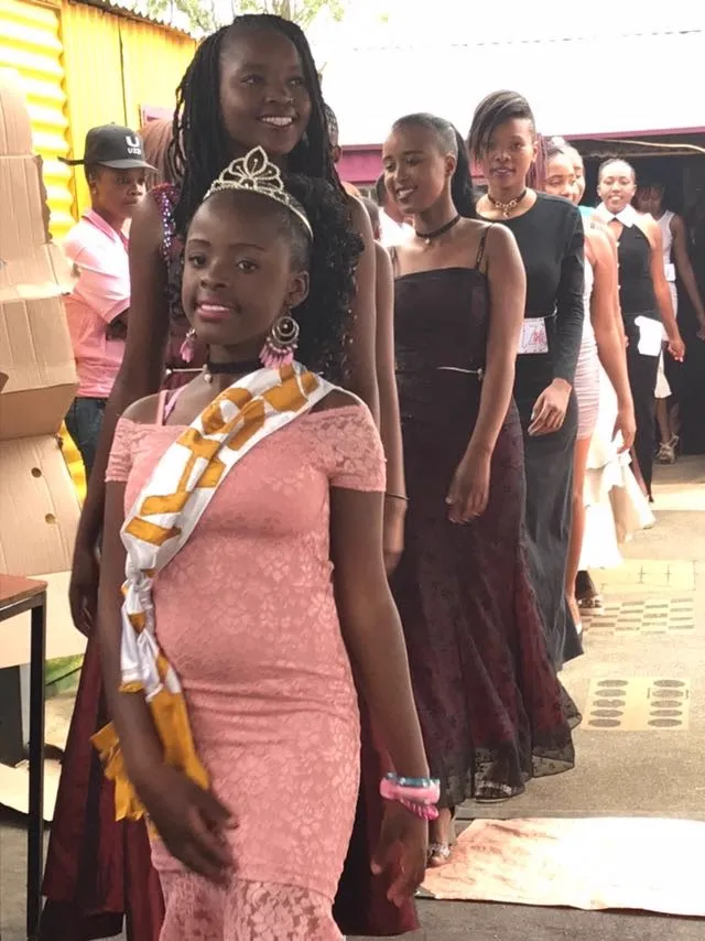 Young women smiling together at the community fashion day