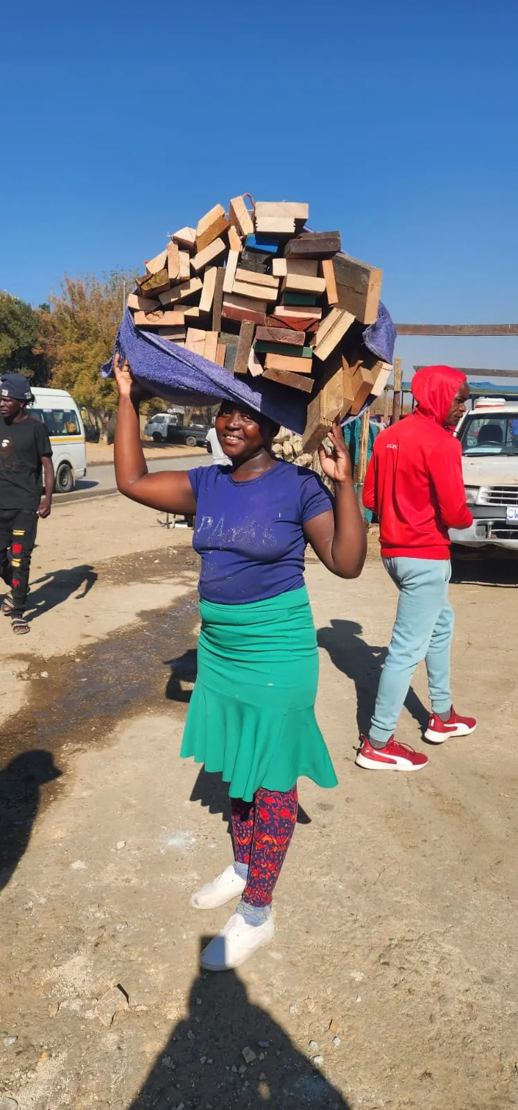 A resident carrying salvaged firewood home