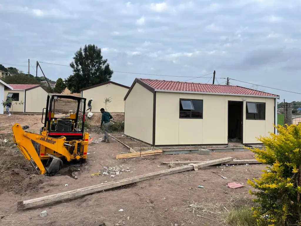 Modular homes going up on site, with plant and crew at work