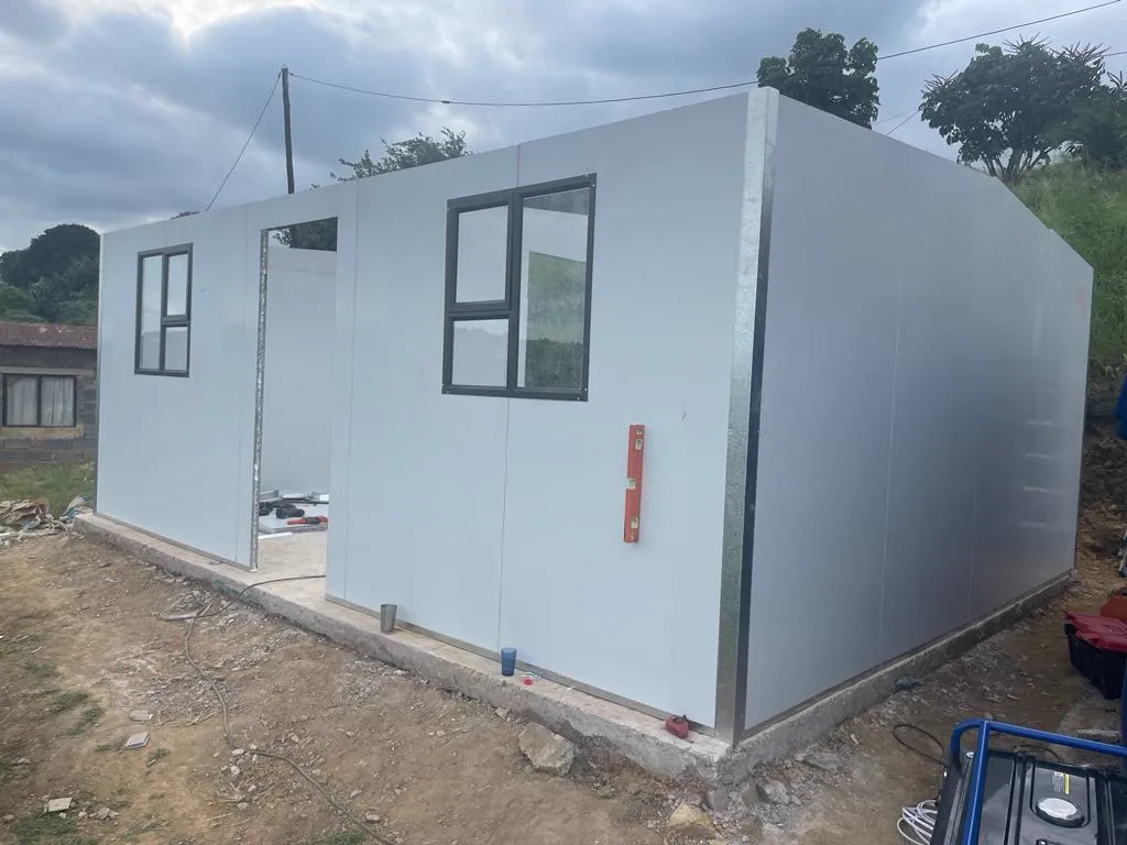 Container-panel walls going up on a modular unit