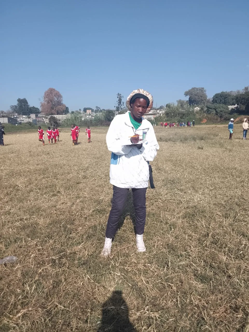 A coach taking notes on the sidelines during a match