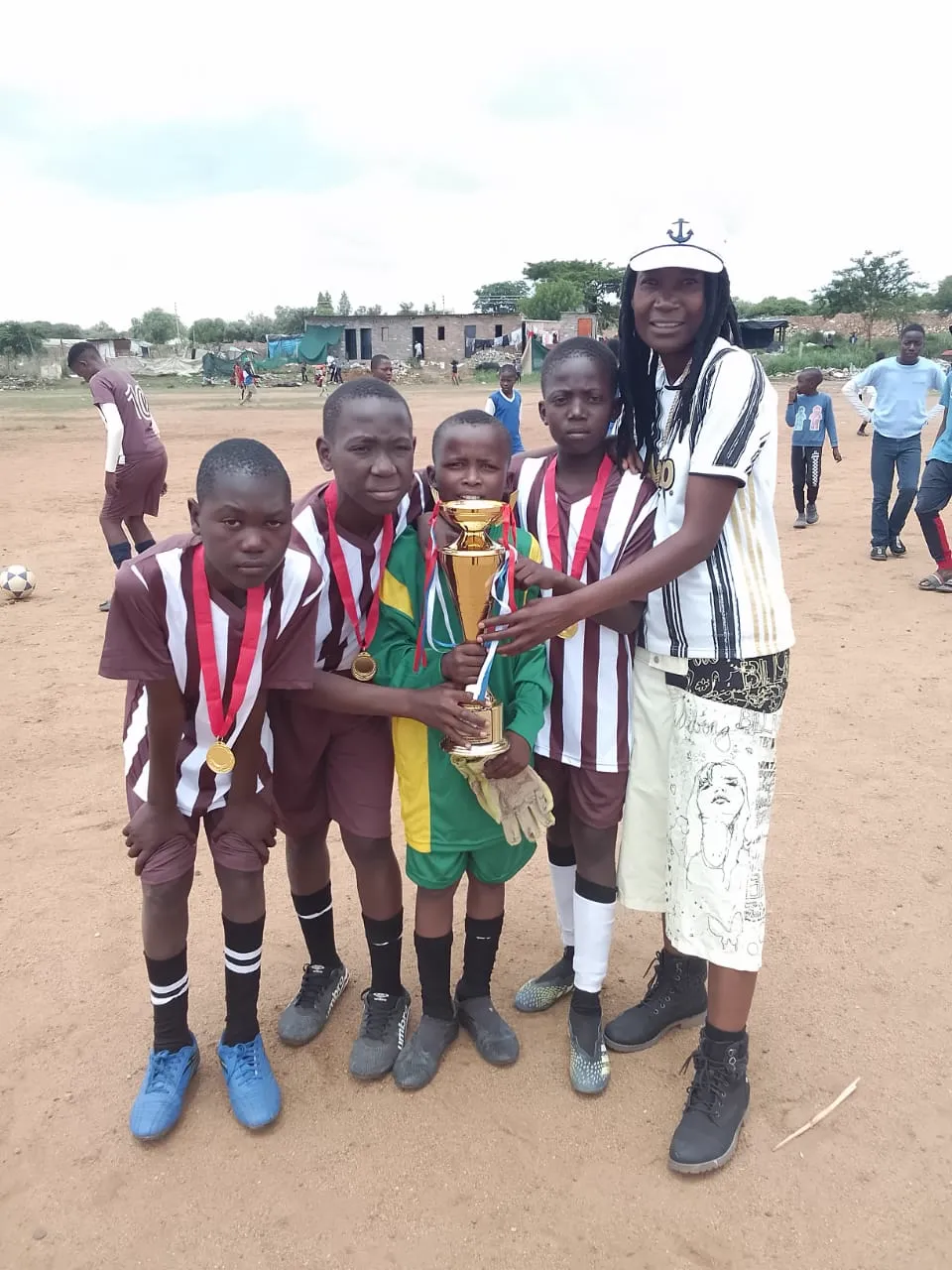 Team lifting the cup with their coach